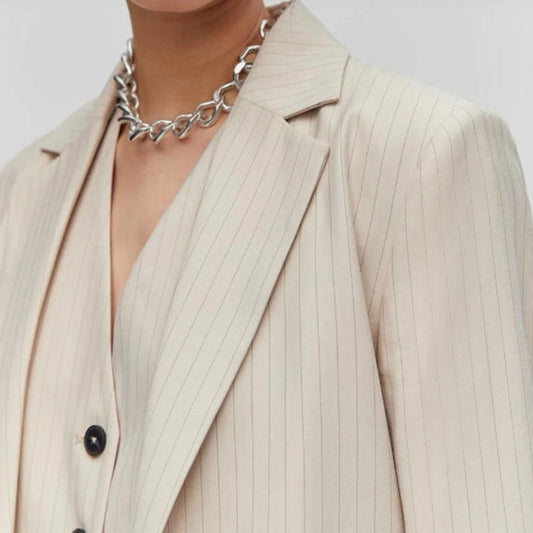 Beige pinstripe suit jacket worn by a person with a neutral background